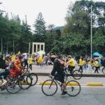 a group of people riding bikes down a street